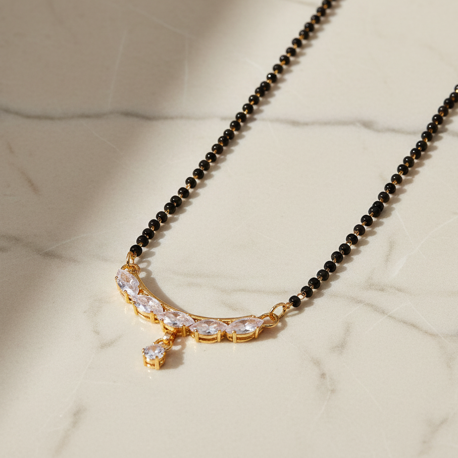 Black beaded necklace with a gold clasp on a marble surface