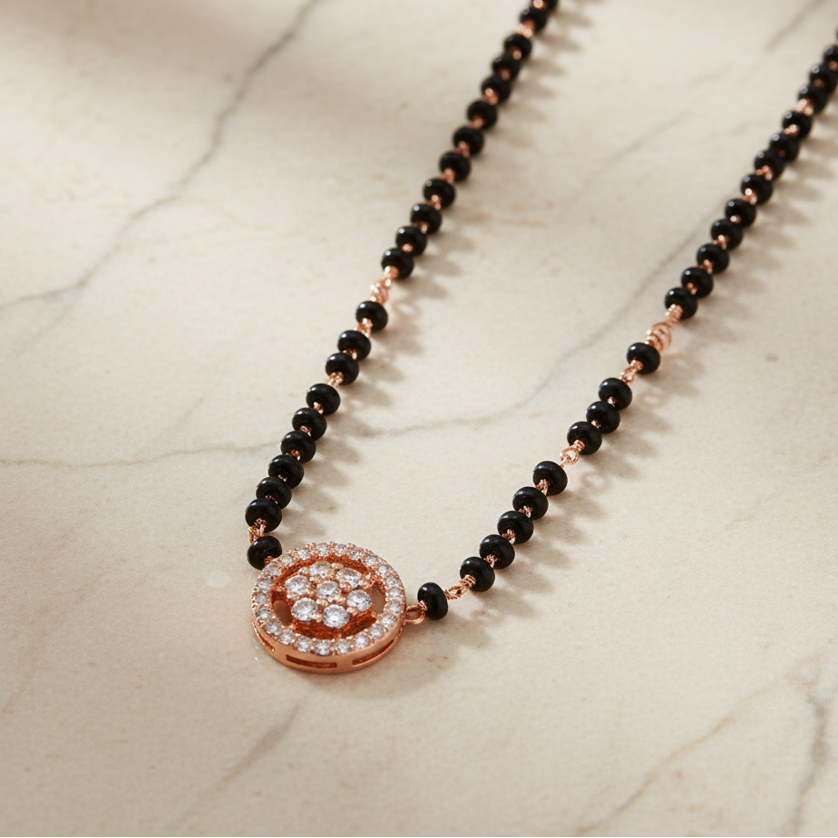 Necklace with black beads and a rose gold clasp on a marble surface